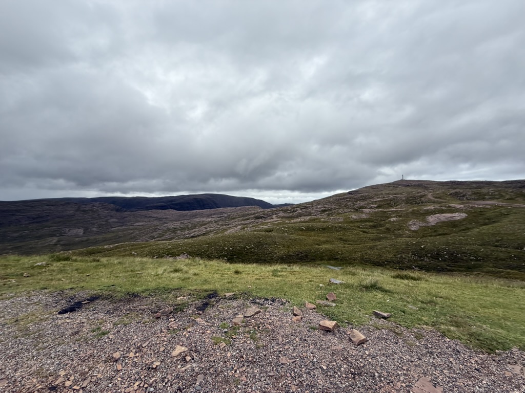 View from the top of Applecross Pass over rugged hills under cloudy skies.