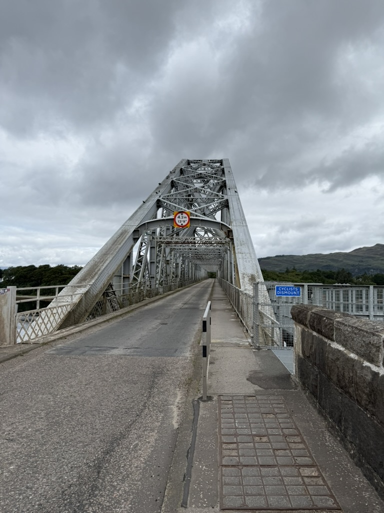 Connel Bridge, a single‑lane metal truss bridge under cloudy skies