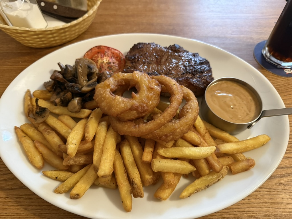 Steak served with fries, onion rings, mushrooms, grilled tomato, and dipping sauce.