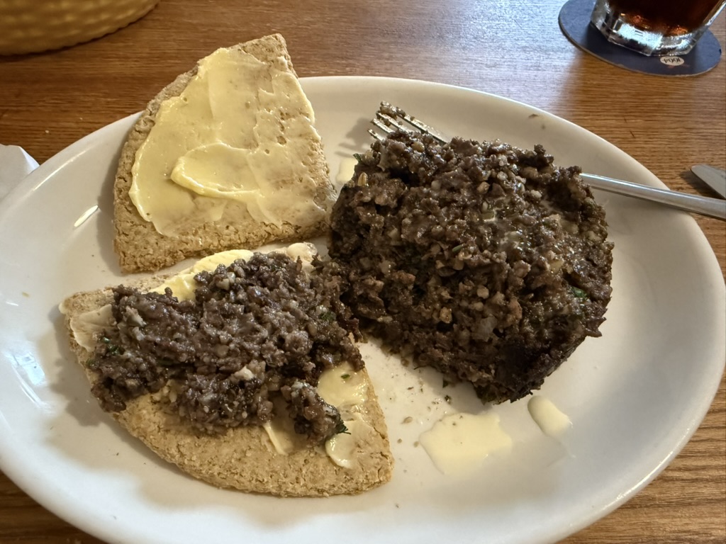 Plate of haggis with buttered oatcakes and a fork on the side.