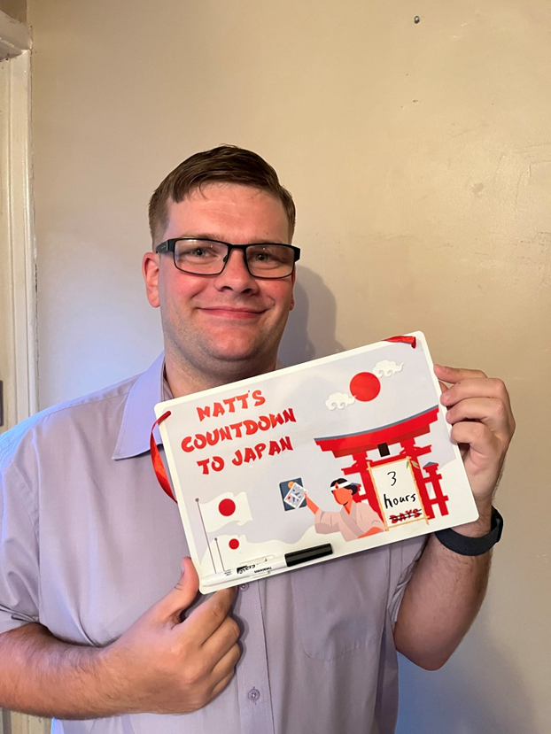 Matthew Jones holding his Countdown to Japan showing 3 hours to go