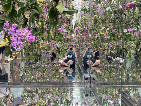 Matthew Jones taking a distant selfie with floating flowers around him
