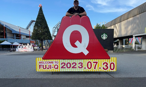 Matthew Jones standing on top of the welcome to Fuji-Q sign.